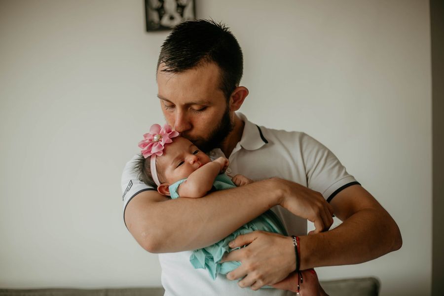 A father kissing his baby daughter